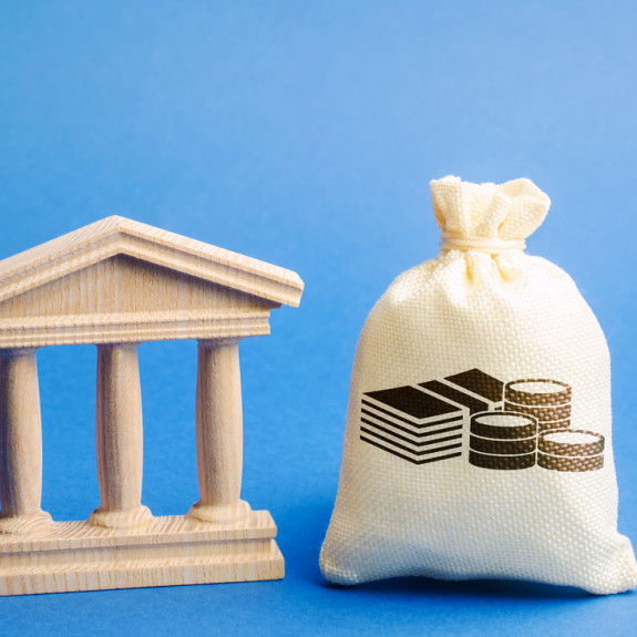 columns of mini government building and bag holding money