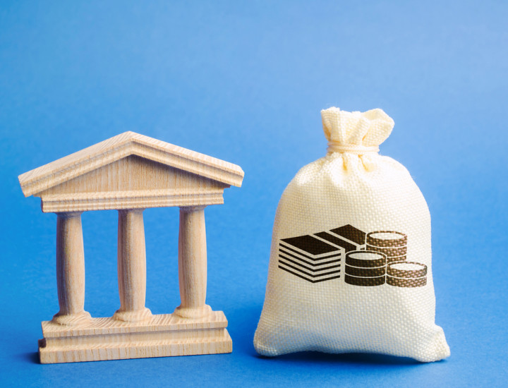 columns of mini government building and bag holding money